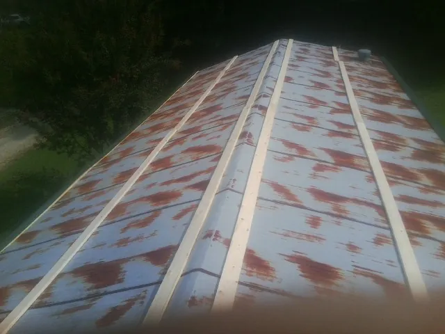 Rusted metal roof panels with new wood purlins before replacement — Storm Damage Roof Repair in Moville by Roofing Brothers