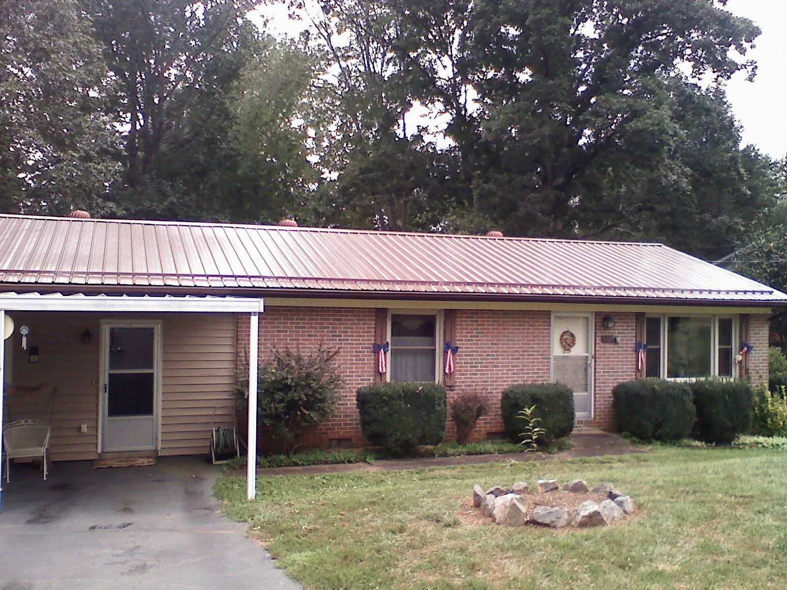 Bronze metal roof and carport on a brick ranch home — Roof Repair work by our crew in Moville