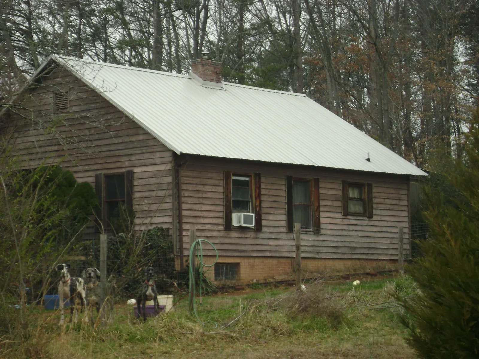 White metal roof on an old wood sided farmhouse, from a Metal Roof Installation job in Moville